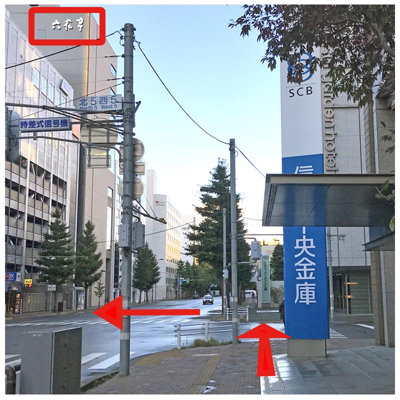 「信金中央金庫」前の信号を渡り（左手上部に「六花亭札幌本店」のロゴが見えます）さらに左手信号も渡り「Times」駐車場に進みます。